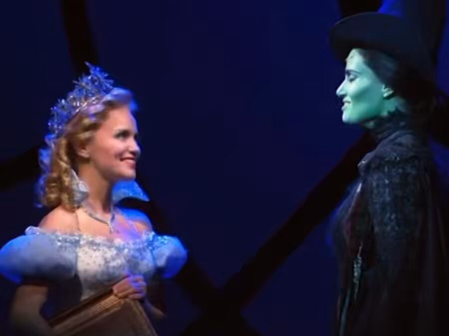 elphaba leaning down to make eye contact with glinda