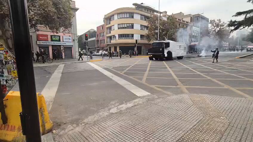 Carro de carabineros lanza chorros de agua contra manifestación de alumnas/os de Universidad Alberto Hurtado quienes exigen la renuncia de un docente acusado de abusos sexules. Alameda Almirante Barroso (13:49)