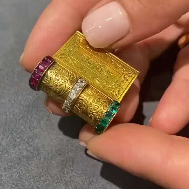 Crafted around 1860, this gold “book” unfolds into a bracelet. Each floral-adorned panel set with emeralds, diamonds, and rubies, spelling out 'souvenir' (French for 'memory').