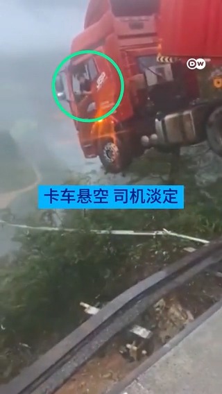 贵州大桥断裂：卡车悬高空，司机淡定 中国贵州省一座大桥因山体滑坡断裂，一辆卡车和里面的司机半挂在断口边缘，万丈深渊之上。
