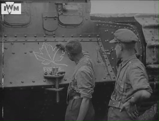 A Canadian soldier of the Tank Corps draws an elaborate Maple Leaf on the nose of his tank, filmed on the Western Front, possibly around the time of the Battle of Arras, April 1917. Film: IWM 1188 <1/2>