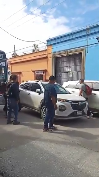 🚨 ¡Indignación ciudadana en #Oaxaca! Cansados del caos vial, usuarios del transporte público retiran a empujones un vehículo estacionado en doble fila sobre la calle de Colón, entre González Ortega y Manuel Doblado. ¿Qué opinas? ¿Justicia ciudadana?👇Déjanos tu comentario.