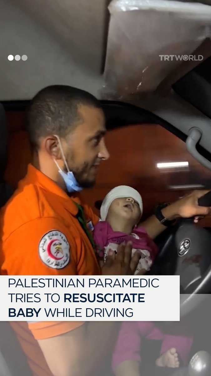 A Palestinian paramedic tries to revive a baby girl with one hand while driving an ambulance with the other, after an overnight Israeli strike on Khan Younis, Gaza on July 9