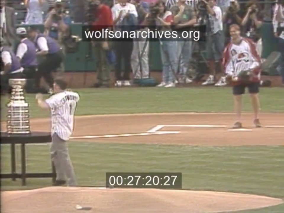 Marc Crawford tosses first pitch to Patrick Roy at Coors Field as Joe Sakic, the Stanley Cup and rest of the Colorado Avalanche look on (1996/06/14).