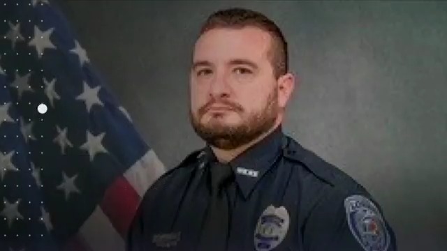 A man with a high-powered rifle and a vehicle filled with weapons ambushed two police officers eating lunch in their car on a remote street, wounding both along with another officer who heard their call for help, authorities said.