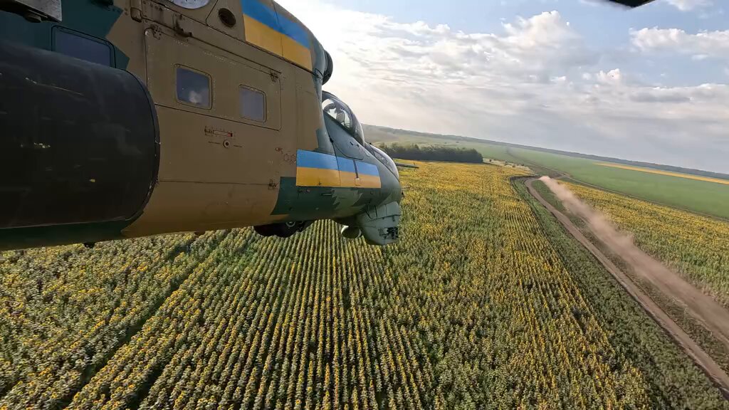Weapons station view from a Ukrainian Army Aviation Mi-24 Hind helicopter gunship flying just feet above the ground as it heads towards the frontline.