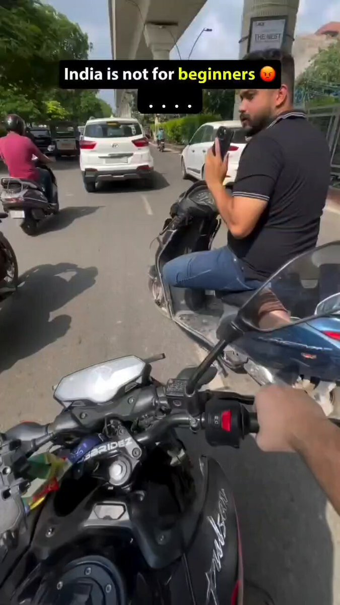 Scooty chalate hue phone use kar rha hai aur ulta akad ra hai