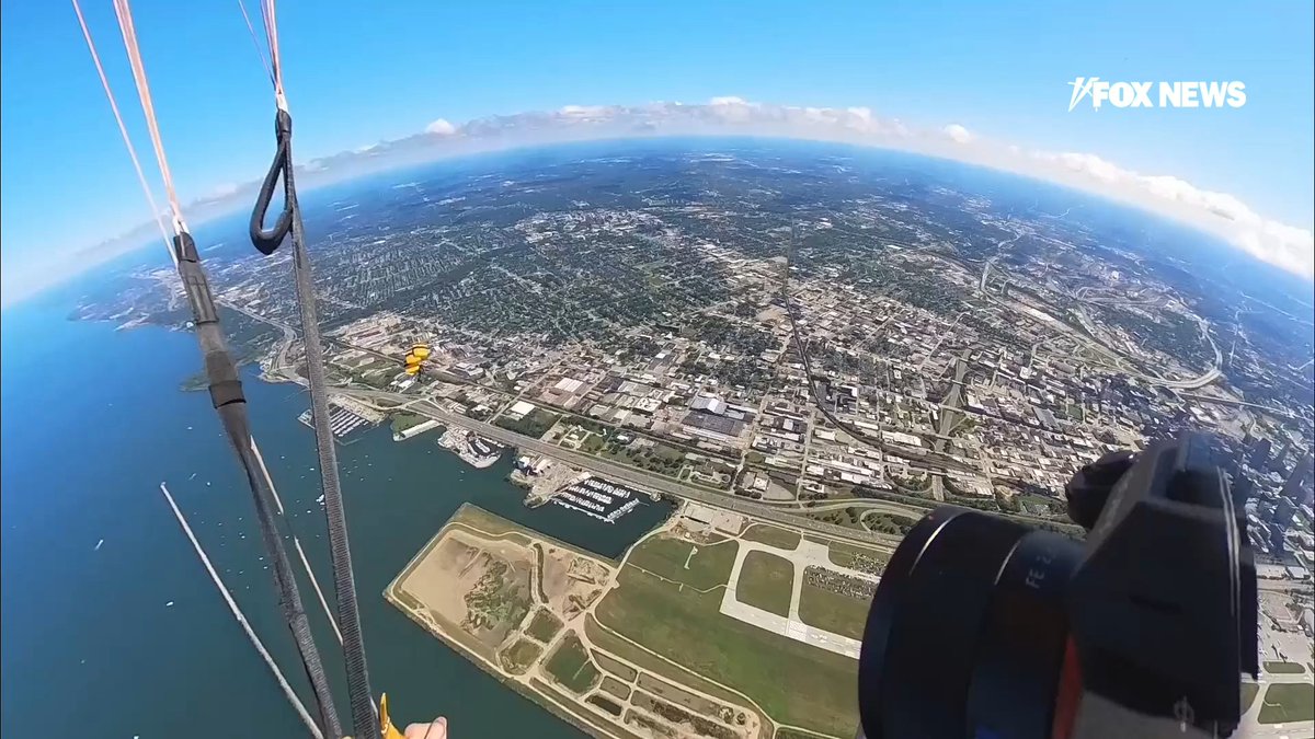 Members of the U.S. Army Parachute Team show off their skills while flying over the Cleveland shoreline during the Cleveland National Airshow.