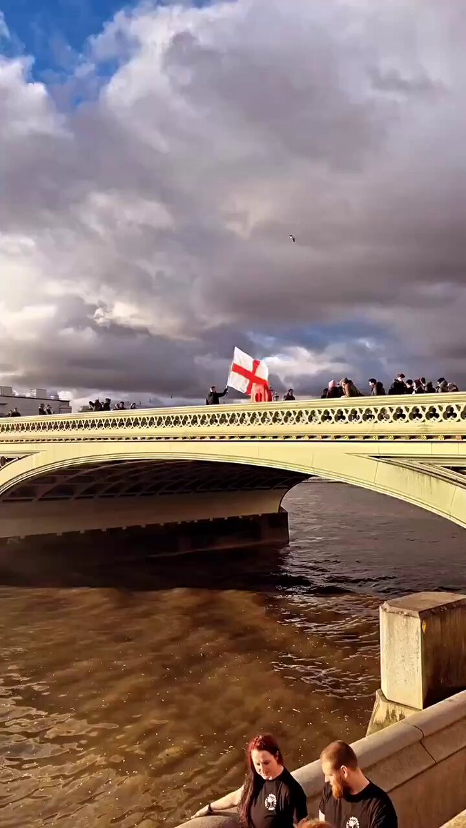 Breathtaking visuals as a man flies an England 🏴󠁧󠁢󠁥󠁮󠁧󠁿 flag over Westminster Bridge 🌉 near Parliament. This is not AI.