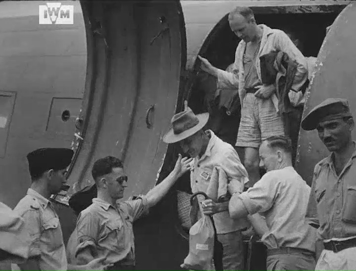 POWs recently freed from Japanese captivity are helped down from an RAF Douglas Dakota at Kallang Airport in Singapore, 1945. Film: IWM ABY 167