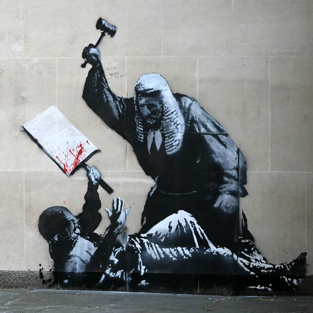'He's gone one wall too many.' Banksy's identity could be revealed as police treat his latest piece as criminal damage. Art dealer John Brandler says the artist has to 'become accountable'.