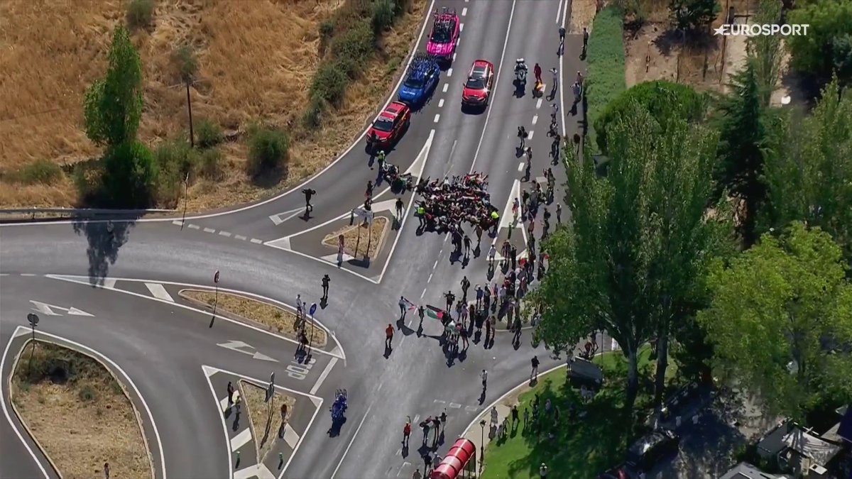 Un grupo de manifestantes invade la carretera e intenta bloquear el paso de los ciclistas. #LaVuelta25