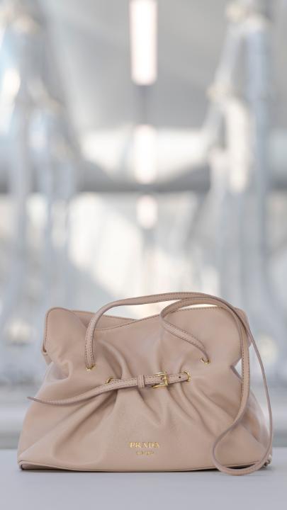 A study in contrasts - harmony and dissonance, elegance and utility. The Prada Dada bag moves fluidly through this duality: soft to the touch, light in construction, and shaped by a belt that transforms function into personal expression. Discover more at: #Prada