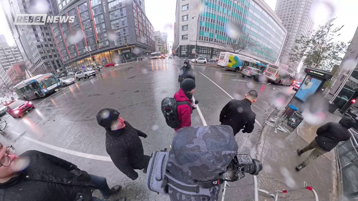 Voici les quelques minutes qui se sont passées avant mon arrestation par la SPVM dimanche dernier. Lors de la manif des Antifa, deux hommes masqués ont commencé à nous suivre en nous intimidant. Nos agents de sécurité les ont bloqués pendant plusieurs minutes, mais les deux voyous refusaient de nous laisser tranquilles. Ils ont eu des gestes physiques à plusieurs reprises envers notre sécurité, frappant le micro ainsi que ma caméra. J’ai donc essayé d’identifier le plus agressif en baissant son masque pour pouvoir le reconnaître, et il est immédiatement allé se plaindre à la police. C’est moi qui ai été arrêtée et mise dans la voiture de patrouille. Après que ma collègue ait montré les vidéos aux policiers et qu’ils aient compris que c’était eux le problème, le gars masqué a décidé de retirer sa plainte et j’ai été relâchée.