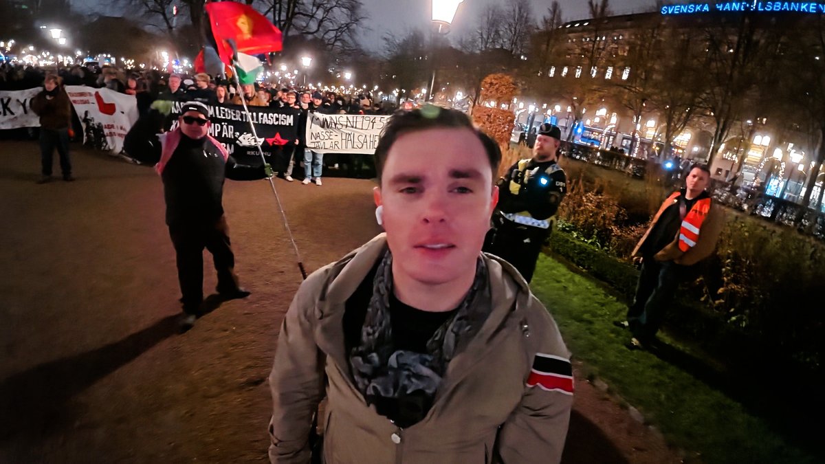 Ökänd mördare dyker upp som ”journalist”! När partiet Alternativ för Sverige (AFS) högtidlighöll minnet av kung Karl XII reagerade extremvänstern genom att skapa fullständigt kaos. Bråk, skrik och ettriga fotografer från vänsterextrema Expo jagade deltagare med kameror och blixtar. På plats fanns även den ökände trippelmördaren Richard Nilsson, som numera framställer sig som någon form av journalist. Vid sin sida hade medieaktivisterna en brokig skara aktivister från Ung Vänster, Revolutionär Kommunistisk Ungdom (RKU) och medlemmar ur terrorstämplade Antifascistisk Aktion (AFA) – med den skattefinansierade heltidsaktivisten Gholamreza ”Kryckmannen” Harati längst fram i ledet. En äldre kvinna rusade plötsligt fram mot min kamera och gapade rakt in i linsen, i vad som verkade vara ett försök att skrämma bort mig. Vid hennes sida stod en maskerad man som gjorde allt för att dölja sitt ögonparti när strålkastaren riktades mot honom. Efter att manifestationen pågått en stund sprang en medarbetare från Frihetsnytt fram mot HBTQ-aktivisten ”Malin” Lääkkö och ryckte åt sig både hans Israel- och Sverigeflagga. Alternativ för Sverige tvingades till slut avsluta minnesstunden tidigare än planerat då kommunisten Erik Lindman Mata lyckats få ett eget demonstrationstillstånd i Karl XII:s park, i vad som verkar vara ett uttryckligt försök att sabotera manifestationen. När minnesstenen avslutats riktade extremvänstern i stället sitt fokus mot mig. Skanderade slagord som ”En sista deportation, Christian över bron” och ”det är värt att sitta inne, slå en nasse med en pinne” ekade över platsen. Först efter en stund manades de via högtalare att sluta rikta uppmärksamheten mot mig och i stället fokusera på sina tal om kommunistisk kamp. Christian Peterson 💸 Stötta min journalistik genom att swisha ett bidrag till 123-697 89 69. 🫵 Vill du ta del av exklusivt innehåll? Bli då prenumerant för endast 60 kr/mån. 📹 Se reportaget: Detta är en återpublicering av text och video från Ansvarig utgivare är David Eriksson.