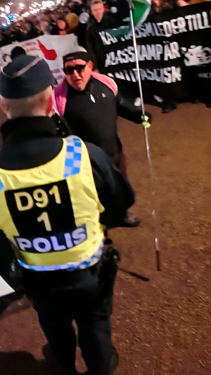 Gholamreza "Kryckmannen" Harati vrålade “Backa fascisten!” – men fick omedelbart mothugg av polisen, som lugnt förklarade att jag har full rätt att bevaka deras lilla jippo. Och ärligt talat – vad är det med honom och det där ständiga behovet av dramatik? Det verkar omöjligt för honom att bara stå bredvid sina kamrater. Han måste alltid spela huvudrollen, oavsett hur pinsamt det blir.