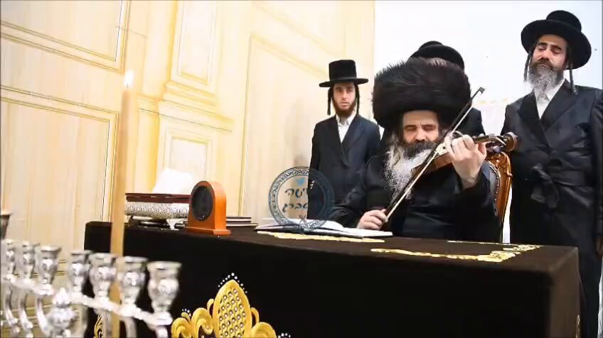 טרי טרי מהנר הראשון. הניגון בכינור המפורסם של האדמו"ר מזוטשקא תוך כדי שהרבי מסמן עם עיניו לקהל להתחיל לשיר (צילום: שוקי לרר)