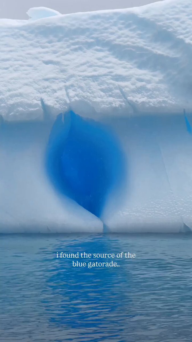 Un enorme iceberg flota en el océano tras desprenderse de un glaciar. Su llamativo color azul se debe a que el hielo denso y sin burbujas absorbe las longitudes de onda rojas y amarillas, dejando la luz restante azul.