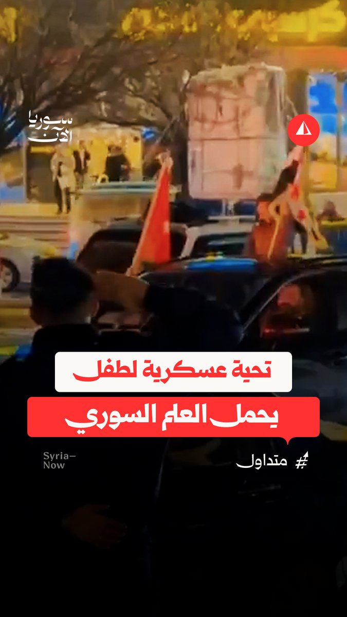 تحية عسكرية متبادلة بين عنصر أمن أردني وطفل يحمل العلم السوري خلال احتفالات شهدتها مدينة عمّان إثر تأهل النشامى إلى نهائي بطولة كأس العرب