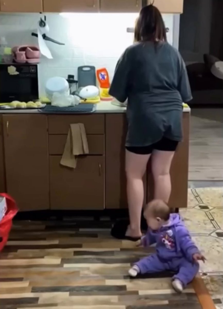 This Mom was struggling to calm the baby while cooking. Her cat noticed this, and stepped in to help her out