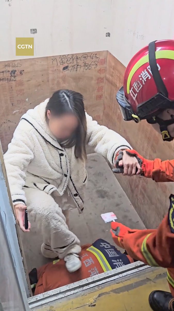 In east China's Jiangxi Province, a pregnant woman was trapped in a malfunctioning elevator, unable to exit due to a gap between the elevator cabin and the landing. A firefighter got down on all fours and offered his back as a "human step," helping her to safety. #ChinaBuzz