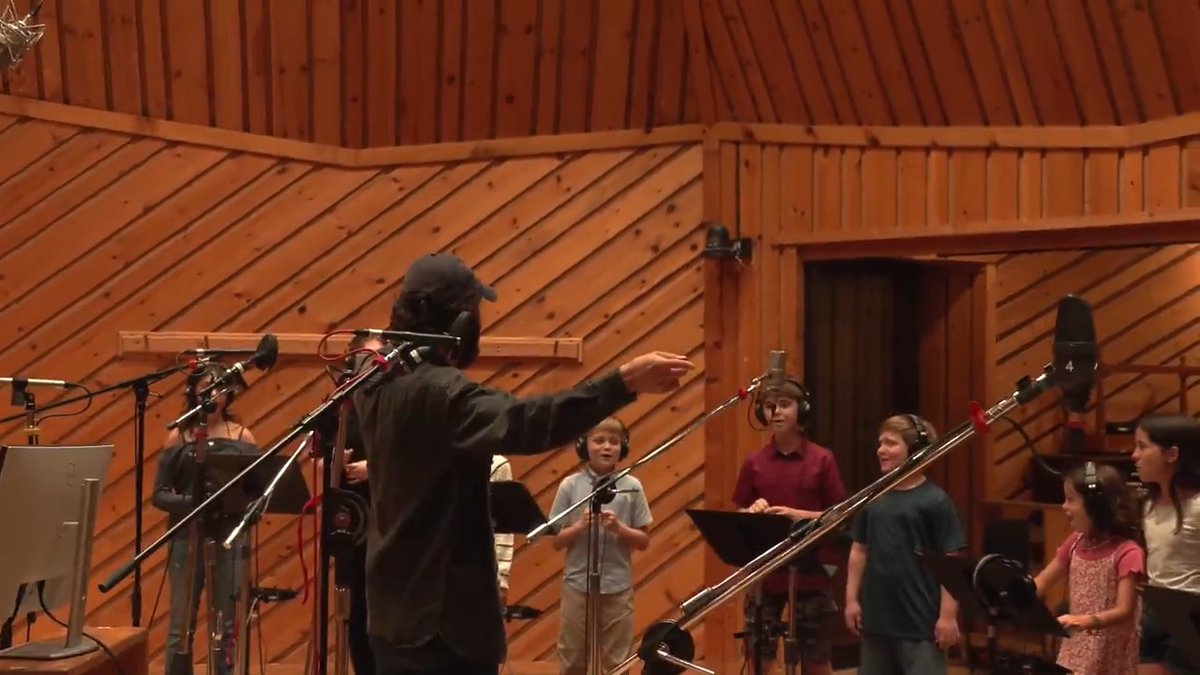 Christmas caroling. Behind the scenes with Josh Safdie, conducting a special rendition of Alphaville's "Forever Young" for MARTY SUPREME.