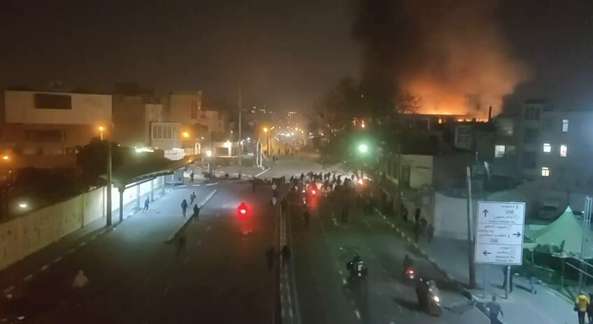 Received video from "Sabalan Street, #Tehran – Thursday, January 8, 2026" Flames from the burning Tax Administration Office in East Tehran are visible on the right side of the frame. #Iran