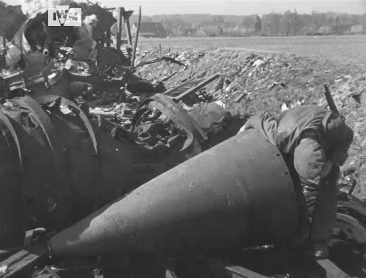 British troops examine and pose next to a V2 rocket after the train carrying it was wrecked in an RAF airstrike near Nienburg, Germany, 16 April 1945. Film: IWM A70 301-3