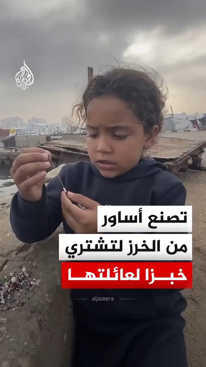 في ميناء غزة البحري، ورغم برودة الطقس.. تواصل طفلة فلسطينية جمع حبات الخرز وصنع أساور صغيرة، علّها تبيعها لتؤمّن خبزا لعائلتها #فيديو