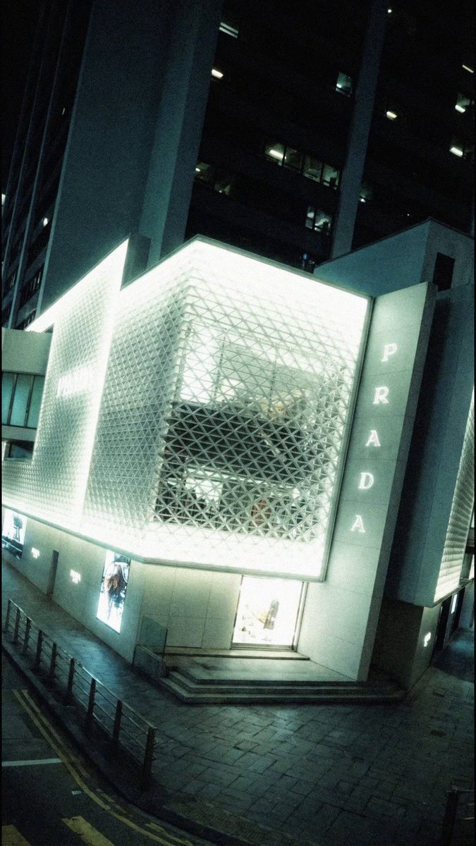 Prada inaugurates its new boutique inside LANDMARK Hong Kong, renewing more than two decades of presence in the city. Extending across three levels, the off-white steel façade features the Prada triangle pattern, paired with Porto Bianco stone, wrapping the building corner between Des Voeux Road and Ice House Street. Within the boutique, special furnishings inspired by Italian design from the 1950s and wooden screens define areas with depth, visibility, and an intimate dimension. #Prada