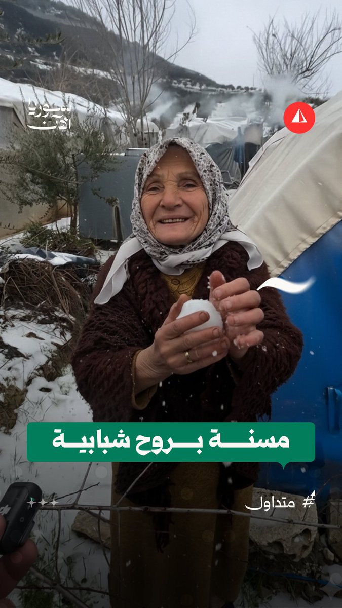 ضحكتها لا تفارق وجهها.. مسنة تحتفي بالثلج داخل مخيمات قرية خربة الجوز في ريف إدلب