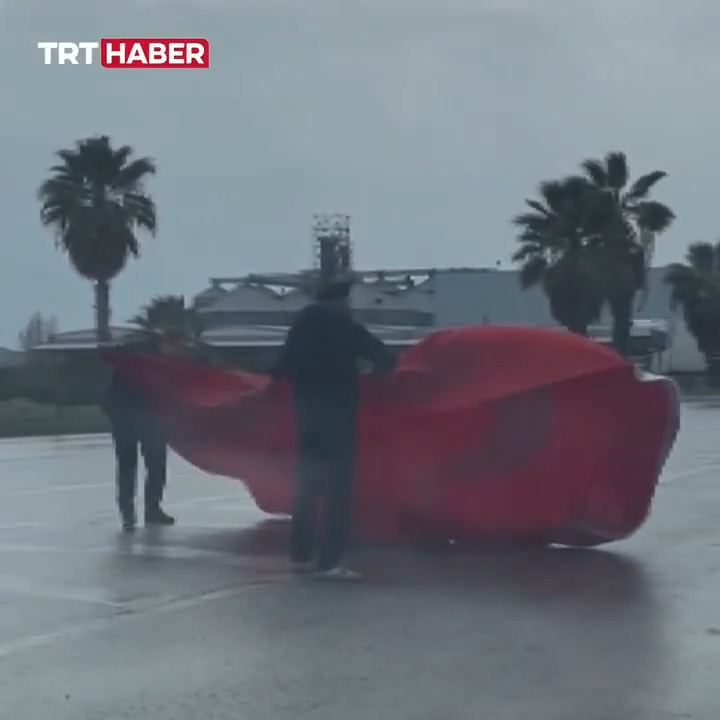 Mersin’de şiddetli rüzgar nedeniyle yola düşen Türk bayrağını sürücüler kaldırdı.