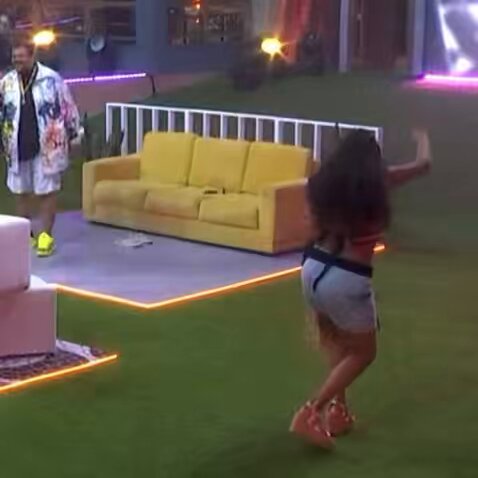 sol dançando segurando uma peruca loira