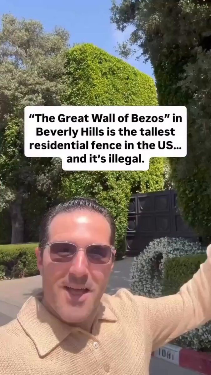 🚨 JEFF BEZOS BUILT A TOWERING ILLEGAL PRIVACY FORTRESS IN BEVERLY HILLS - THE “GREAT WALL OF BEZOS” According to the man in this video, the massive hedge surrounding **Jeff Bezos’ Beverly Hills estate, nicknamed the “Great Wall of Bezos”, violates local code. City rules cap residential hedges at 42 inches. This one rises multiple stories high. Instead of trimming it, Bezos reportedly pays over $1,000 a month in fines and the city of Beverly Hills lets it stay. No enforcement. No consequences Just a monthly fee to break the rules. If fines don’t stop billionaires, are they laws or just prices?