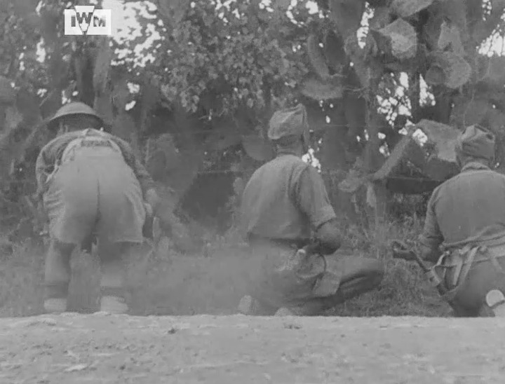 Men of D Company, 5th Seaforth Highlanders filmed on a roadway near Francofonte, Sicily, while under fire from German snipers, July 1943. Film: IWM AYY 502/2/1