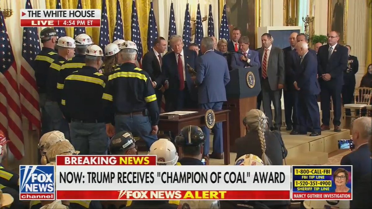 Trump receives a trophy of a coal miner that resembles him with a plaque that reads "The Undisputed Champion of Clean Coal"