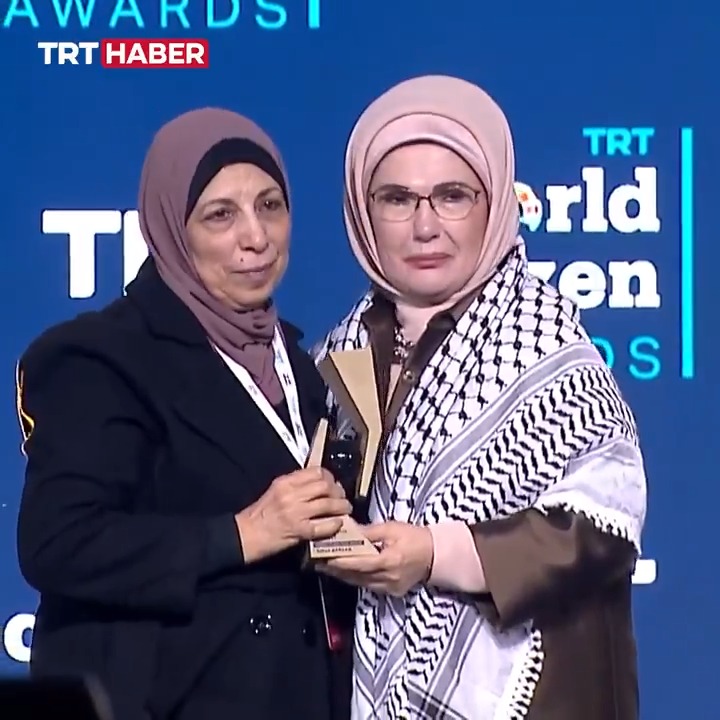 Emine Erdoğan, Gazze’de görev yaparken şehit olan foto muhabiri Yahya Barzaq’a verilen "Yılın Dünya Vatandaşı Ödülü"nü anne Yousra Barzaq’a takdim etti. Anne Barzaq, omzundaki kefiyeyi Emine Erdoğan’a verdi. Birbirine sarılan iki anne, duygusal anlar yaşadı. #TRTWorldCitizen