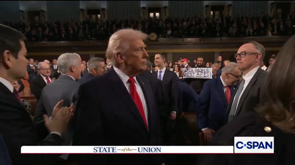 President Trump greets Chief Justice Robert and other members of the Supreme Court. In the background, U.S. Representative Al Green holds up a sign that reads: "Black People Aren't Apes" #SOTU #SOTU2026