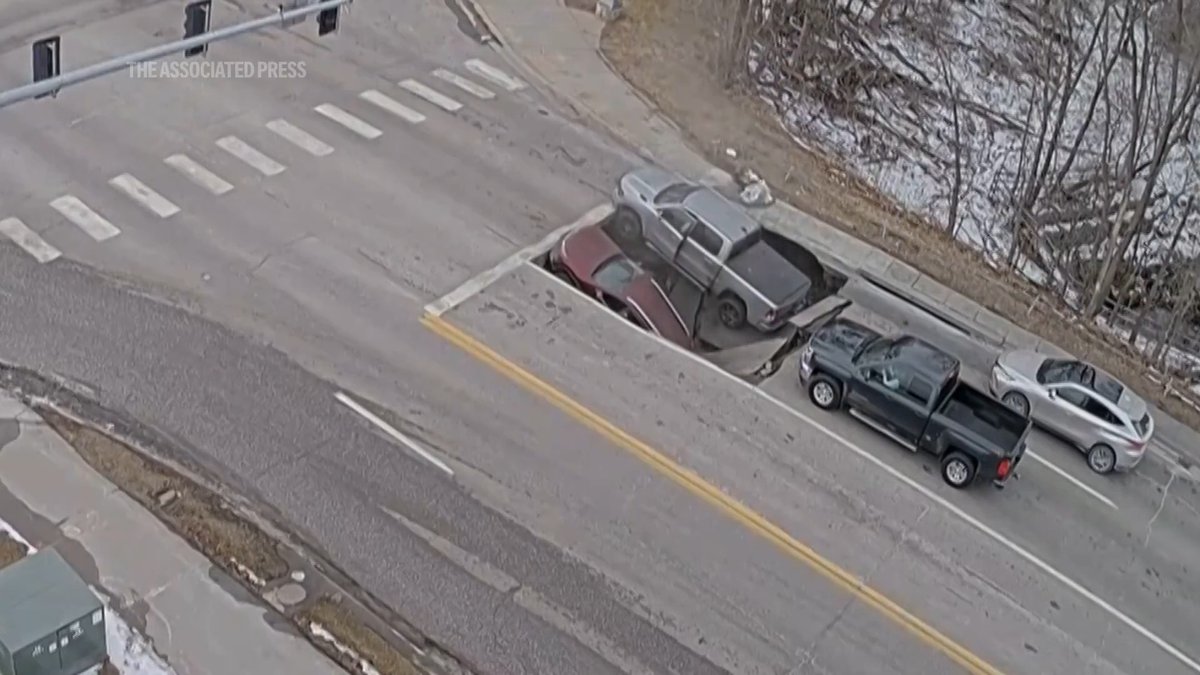 A street collapsed in Omaha, Nebraska, on Tuesday, swallowing two vehicles waiting at a red light. Police say the drivers climbed out and weren’t injured.
