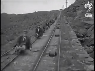 Quarry workers heading home (1935). A small truck with a simple handbrake used to ride the rails at the end of a shift. Gravity-powered commute.