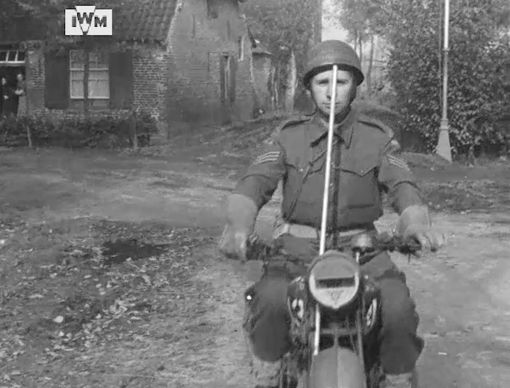 A rider from 11th Armoured Division’s Corps of Military Police demonstrates how to neutralise a German trip‑wire trap near divisional headquarters at Deurne, the Netherlands, October 1944. Film: IWM A70 183-3