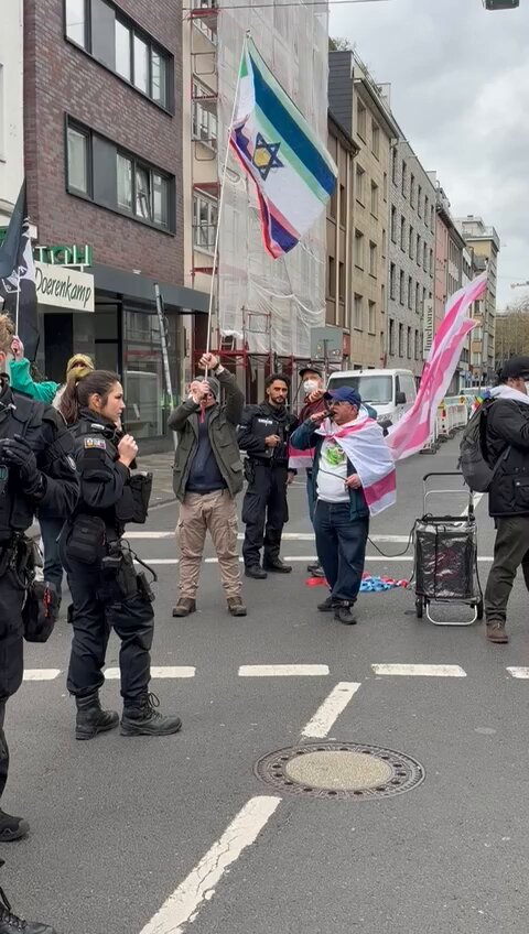 A pro-Israel “antifa” waves a small noose at pro-Palestine protesters in Düsseldorf