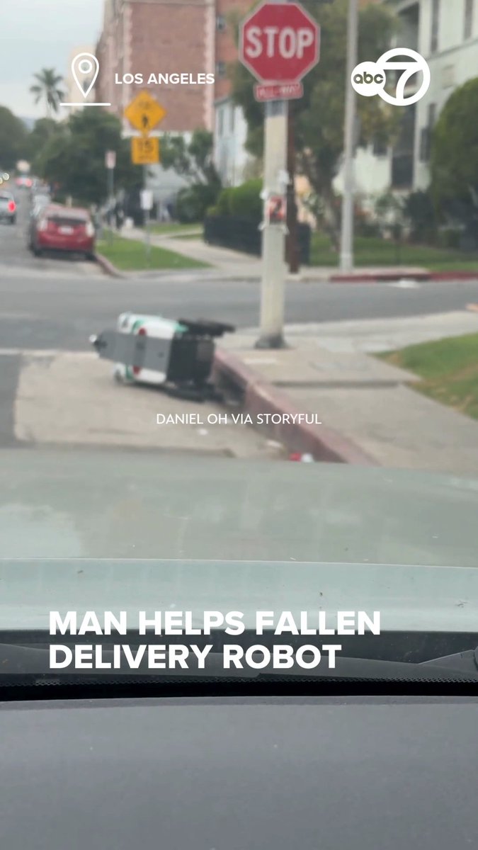 A man in Los Angeles found humor in the moment after stopping to help a stranded delivery robot. Video from Daniel Oh shows him getting out of his car, approaching the tipped-over robot named Tasha, and lifting it back upright.