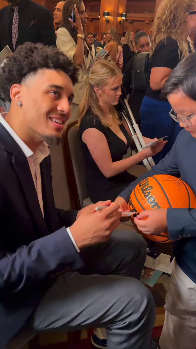 Yaxel Lendeborg signing an autograph and posing for a photo with a young Michigan Men's Basketball fan at the John R. Wooden Award Ceremony 🙌