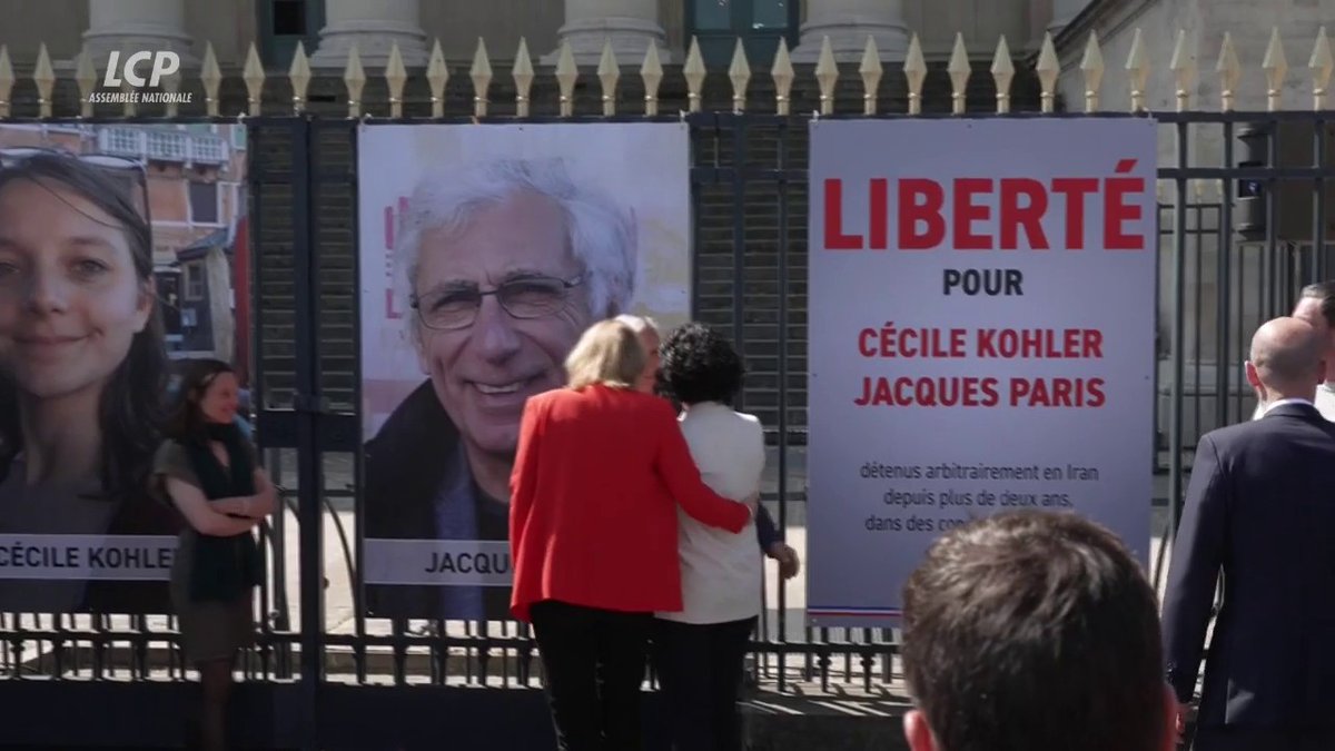 Cécile Kohler et Jacques Paris, ex-otages en Iran, procèdent au décrochage de leurs portraits des grilles de l'Assemblée nationale, en présence de Yaël Braun-Pivet, de Jean-Noël Barrot ou encore d'Ayda Hadizadeh Députée. #DirectAN