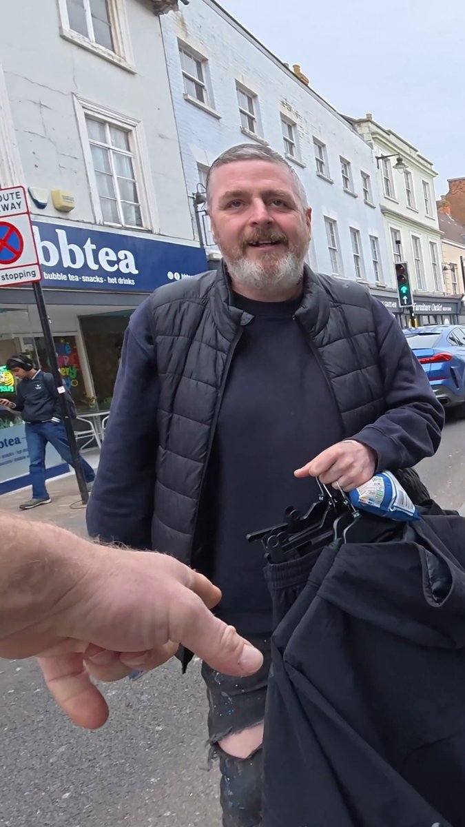 Man walks out of JD Sports with heap of clothes in Bedford