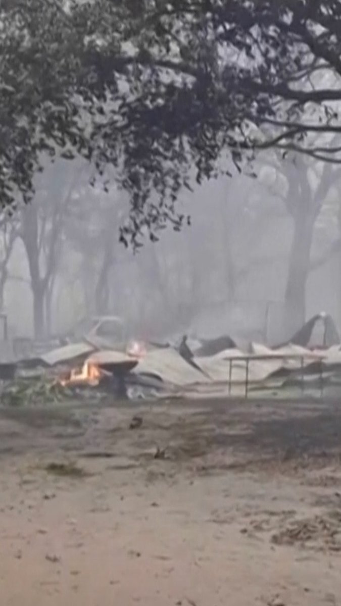 A woman recording the damage caused by a wildfire in Brantley County, Georgia, surveyed the smoky scene of burned out vehicles and other debris. Wildfires have ripped through the South, forcing hundreds of Georgia residents to flee. Driven by strong winds and low humidity, the two biggest fires in southern Georgia have spread rapidly over the past two days and destroyed more than 50 homes in rural areas.