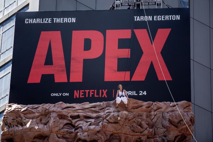 Charlize Theron rock-climbed a billboard in Times Square just to tell you that APEX is NOW ON NETFLIX.