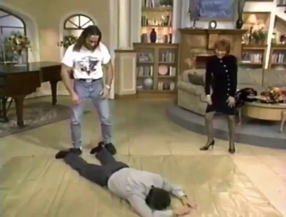 Bret Hart puts Regis Philbin in the Sharpshooter.