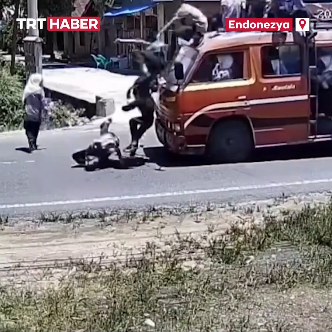 Minibüsün üstünde tehlikeli yolculuk... Endonezya'da sürücünün yayaya yol vermek için frene basmasıyla aracın üzerindeki öğrenciler yola savruldu.